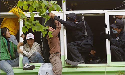 4일 오후 대추분교에 진입한 경찰이 2층에서 농성중인 주민과 시민사회단체 회원들을 강제연행하려하자 일부 대학생들이 창문틀을 잡고 저항하고 있다. 